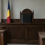 Sală de judecată cu steagul românesc