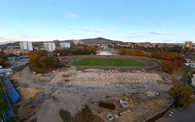Panoramic view of Corvinul Hunedoara stadium during demolition with construction debris and surrounding city landscape