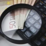 Bancnote, lupă și calculator științific