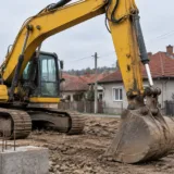 Excavator pe un șantier de construcții într-o zonă rezidențială