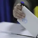 O mână introduce un buletin de vot într-o urnă