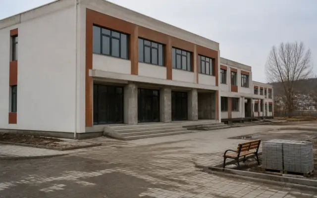 O clădire modernă de școală sau campus școlar cu două etaje, aflată în faza finală de construcție sau recent finalizată