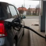 Partea din spate a unui autoturism de culoare gri închis aflat la o benzinărie