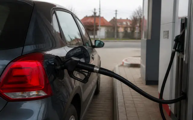 Partea din spate a unui autoturism de culoare gri închis aflat la o benzinărie